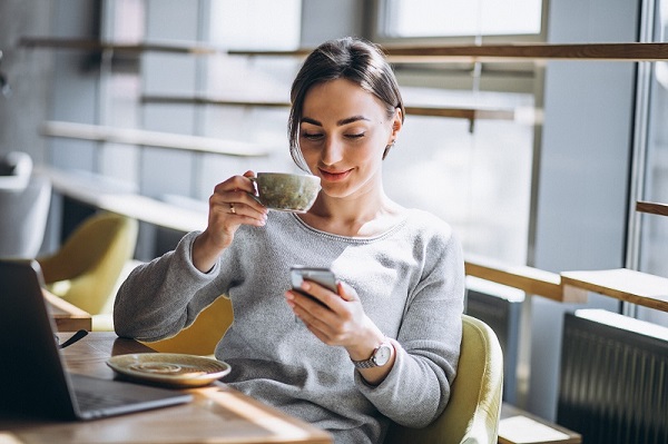 woman-sitting-in-a-cafe-drinking-coffee-and-working-on-a-computer woman-sitting-in-a-cafe-drinking-coffee-and-working-on-a-computer